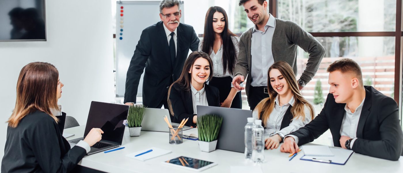 Staff meeting. Group of   young modern people in smart casual wear discussing something while working in the creative office . Business time..